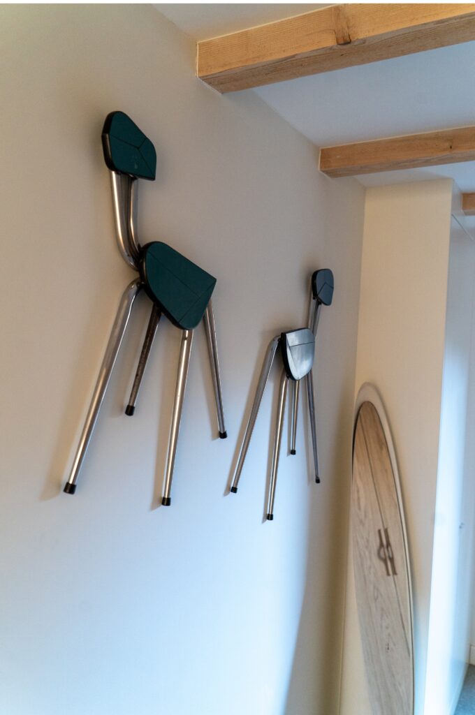 Deux chaises design accrochées au mur dans un dressing sur-mesure avec façades chêne naturel Popline.
