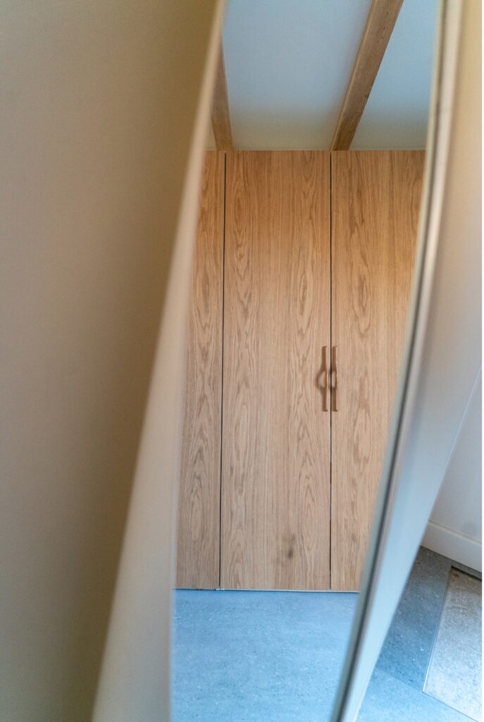 Vue latérale d’un dressing IKEA Pax avec des façades Popline en chêne naturel.
