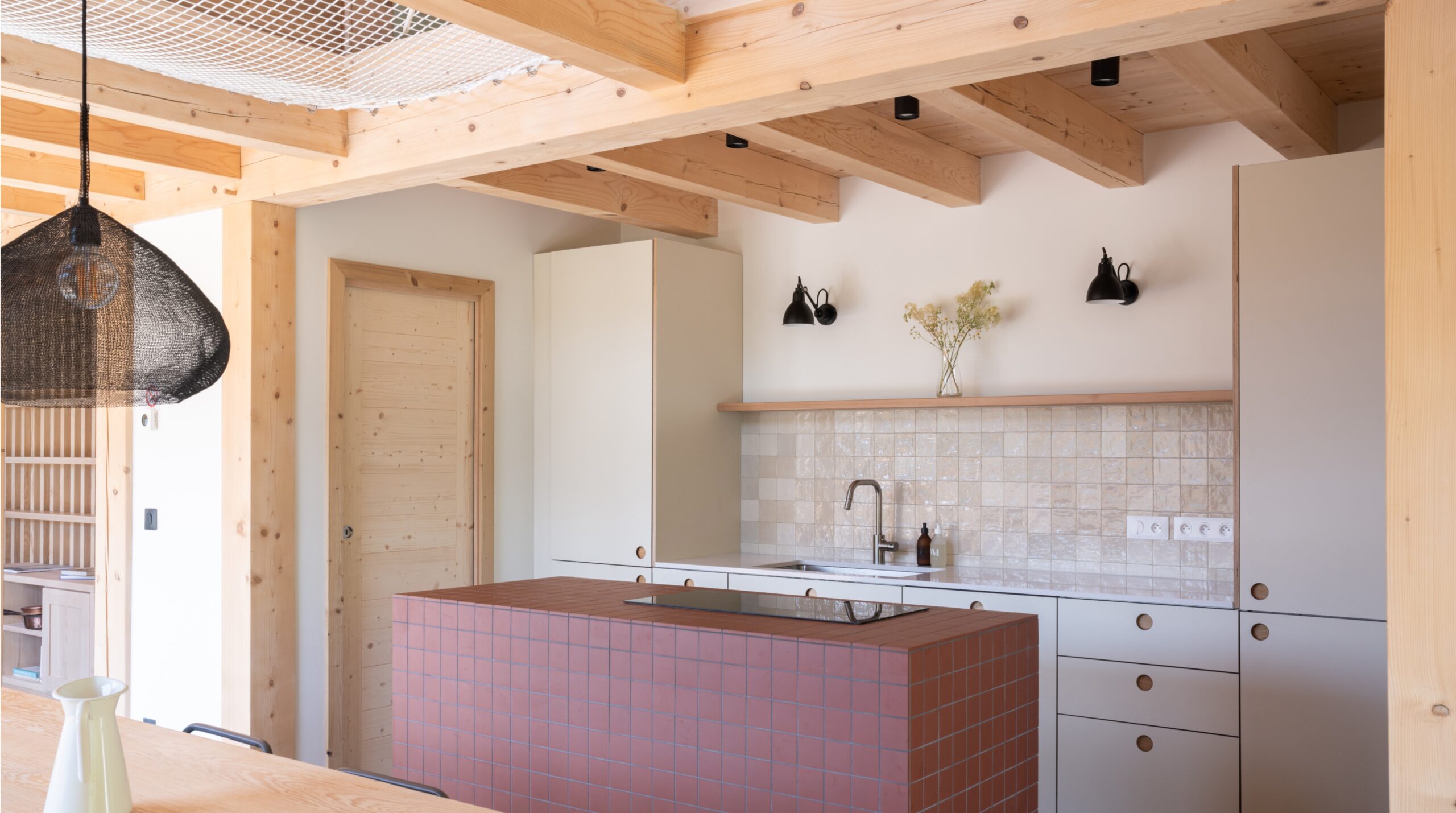 Cuisine IKEA personnalisée dans un chalet moderne avec îlot central carrelé.