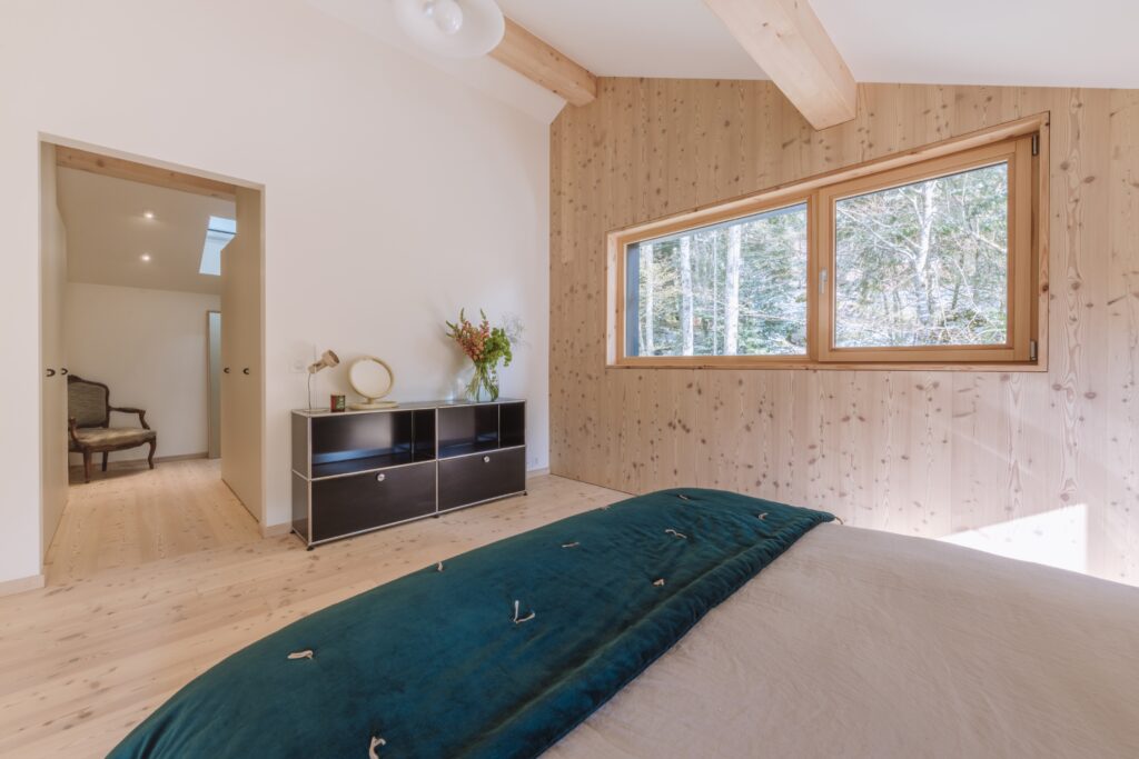 Vue complète d'une chambre avec un dressing Pax sur-mesure à façades UNI, intégré dans un chalet jurassien rénové.